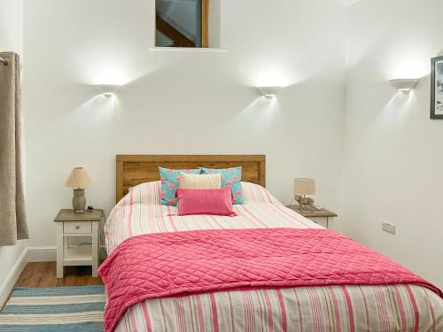 sypialnia z dużym łóżkiem i różowym kocem w obiekcie Maggies Place w mieście Holsworthy