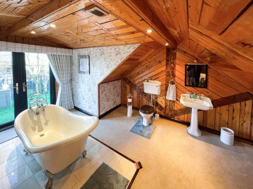 baño grande con bañera y lavamanos en Tennox Stables - Uk39975 en Kilbirnie