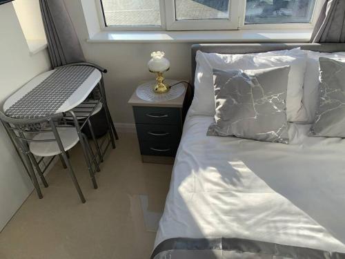 ein kleines Schlafzimmer mit einem Bett und einem Stuhl in der Unterkunft Annex B, a Studio flat in London in Carshalton