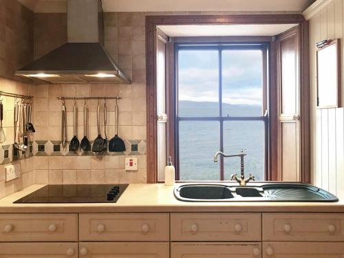 a kitchen with a sink and a window at The Fishermans Cottage in Applecross