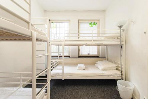 a room with two bunk beds and a ladder at Acco Hostel in Stockholm