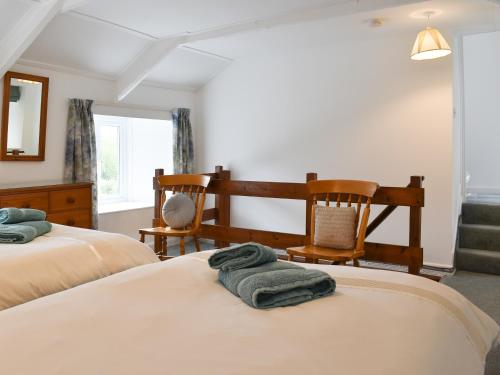 a bedroom with two beds and two chairs at Madderhay - Uk43512 in Lostwithiel