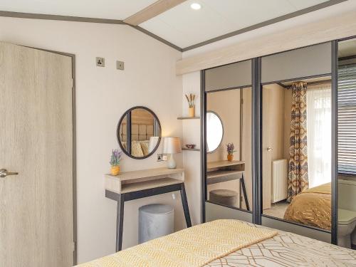 Schlafzimmer mit einem Bett und einem Spiegel in der Unterkunft Ben Vorlich Lodge in Saint Fillans