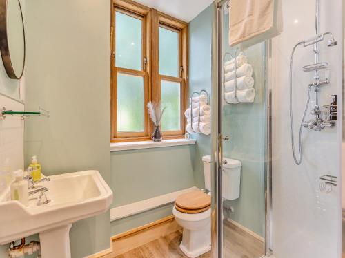 a bathroom with a toilet and a sink and a shower at Gardeners Cottage in Huntly