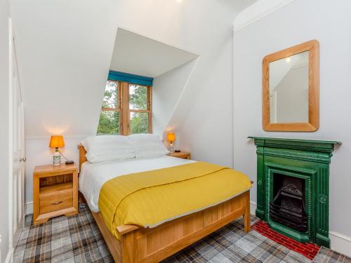 ein Schlafzimmer mit einem Bett und einem Kamin in der Unterkunft Gardeners Cottage in Huntly