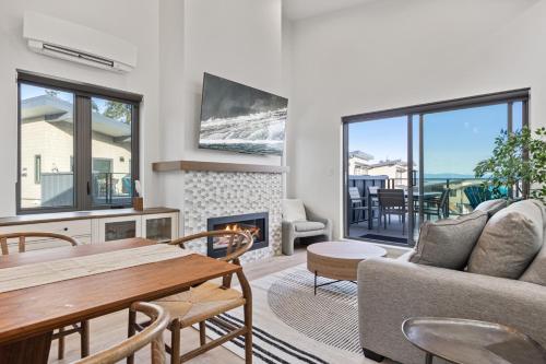 uma sala de estar com uma mesa e uma lareira em Ocean View Townhouse #30 at THE BEACH HOUSE em Campbell River