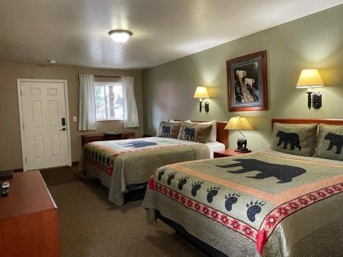a hotel room with two beds and a couch at Antlers Lodge in Cooke City