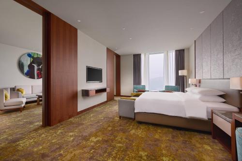 台北的住宿－台北六福萬怡酒店，大型酒店客房设有床和电视。