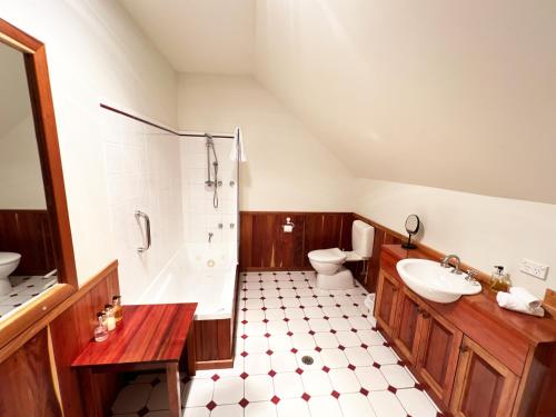 a bathroom with a shower and a sink and a toilet at Risby Cove Boutique Hotel in Strahan