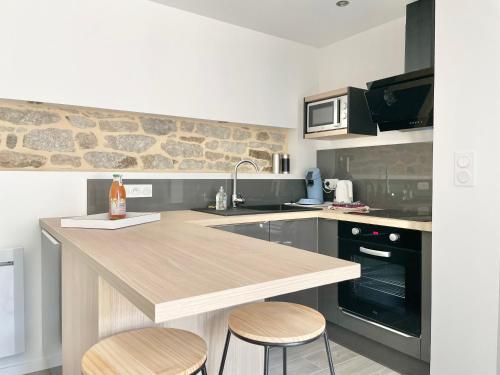 - une cuisine avec un comptoir et deux tabourets dans l'établissement LE CALLOCH 2D - Studio 4 Étoiles - Quartier Gare - Wifi - Netflix, à Quimper