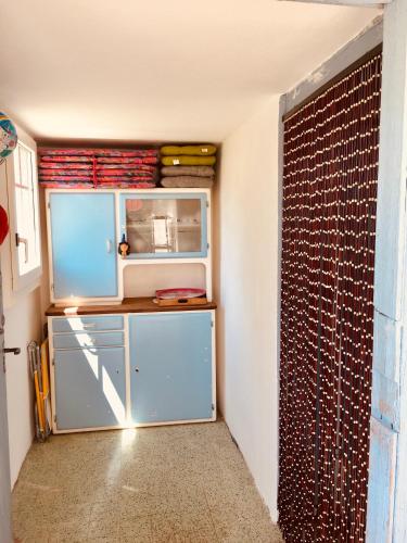 a small kitchen with a blue cabinet in a room at LaTerestone in Les Bayards