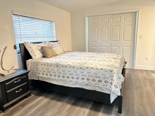 een slaapkamer met een bed, een raam en een deur bij Cottage in Lutz, Florida in Lutz