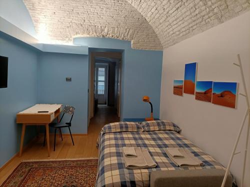 een slaapkamer met een bed, een tafel en een bureau bij Casa D'Alma in Turijn