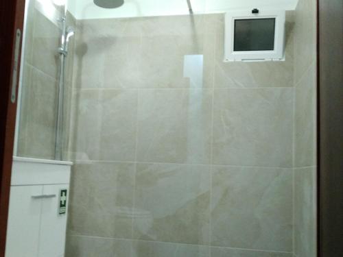 a shower with a glass door in a bathroom at Casa MAR in Madalena do Mar
