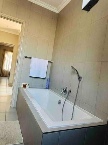 a bathroom with a tub with a towel on the wall at Angel’s Nest Nelspruit in Nelspruit