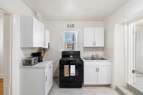a kitchen with a black stove and white cabinets at Studio Casita-15 min walk to Downtown Plaza in Santa Fe