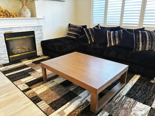 a living room with a black couch and a coffee table at Fragrant Finnish Sauna & Cozy Pool with French 3br in Las Vegas