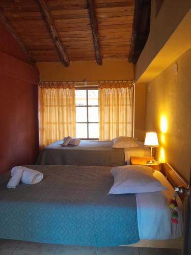 a bedroom with two beds and a window at B&B Sun Gate in Ollantaytambo