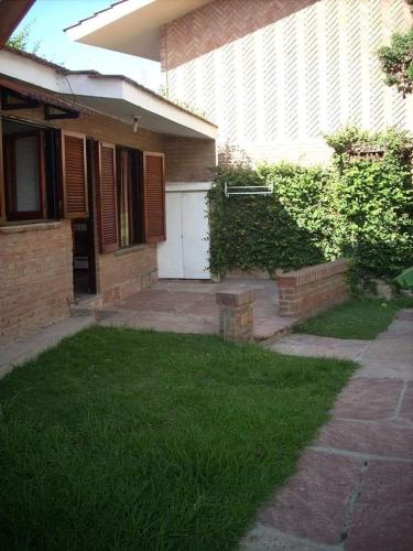 una casa con un patio con césped verde delante de ella en Dpto Villa Carlos Paz en Villa Carlos Paz