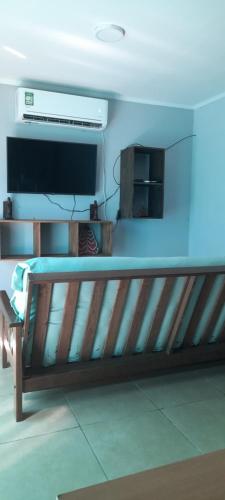 um banco de madeira numa sala com televisão em CASA TOBIAS em Tandil