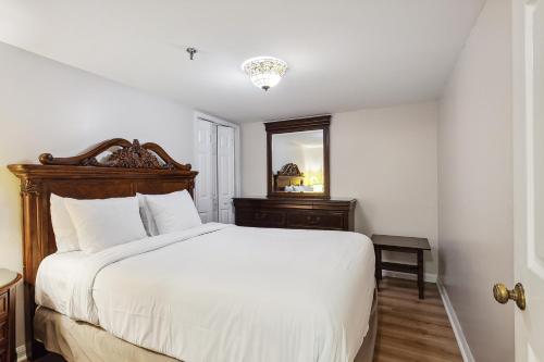 a bedroom with a large white bed and a mirror at Maison Pierre Lafitte in New Orleans