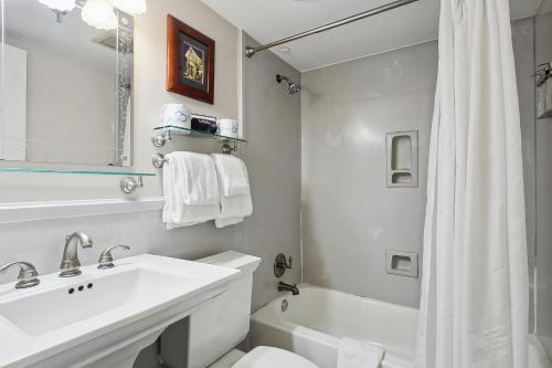 y baño blanco con lavabo, aseo y ducha. en Maison Pierre Lafitte en Nueva Orleans