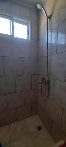La salle de bains est pourvue d'une douche et d'une fenêtre. dans l'établissement CASA TOBIAS, à Tandil