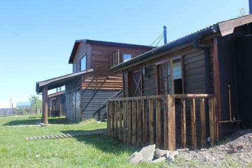a log cabin with a wooden fence in front of it at Dorotea Vista in Puerto Natales