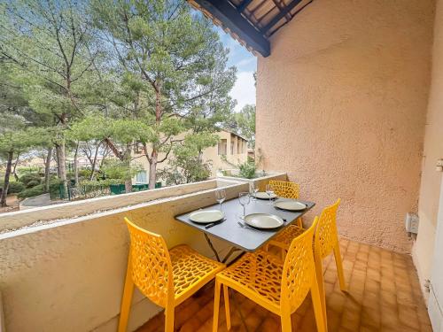 une table et des chaises sur le balcon d'une maison dans l'établissement Villa Bandolaise - 10 min de la plage, à Bandol