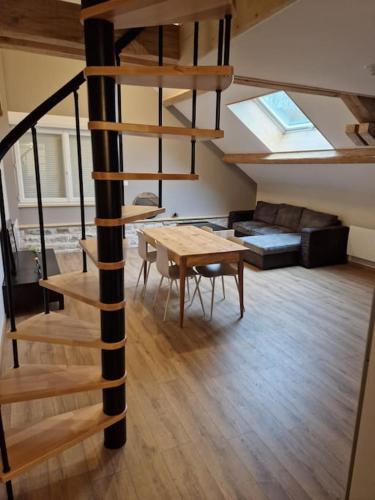 un salon avec un escalier en colimaçon et une table dans l'établissement Appartement Évillers, à Évillers
