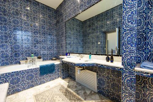 a blue and white bathroom with two sinks and a mirror at Arabesque House in La Marsa