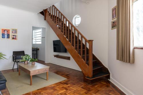 uma sala de estar com uma escada e uma televisão em Sobrado 2 dormitórios no Tatuapé em São Paulo