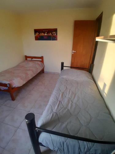 a bedroom with two twin beds and a door at Alquiler por día Gobernador Gregores in Gobernador Gregores