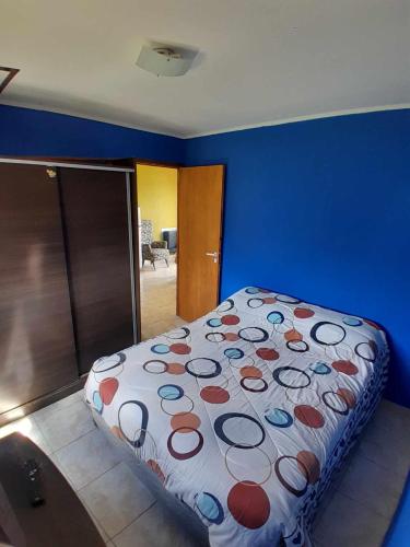 a bedroom with a bed in a blue wall at Alquiler por día Gobernador Gregores in Gobernador Gregores