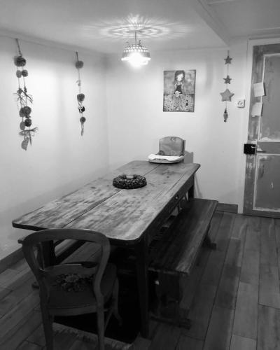 a wooden table and a chair in a room at LaTerestone in Les Bayards