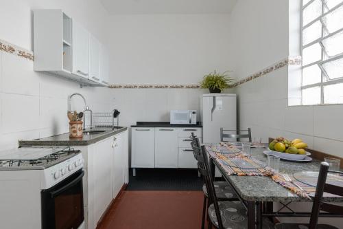uma cozinha com uma mesa com cadeiras e um frigorífico em Sobrado 2 dormitórios no Tatuapé em São Paulo