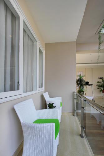 a living room with white chairs and a staircase at Ohana Hotel Kuta in Kuta
