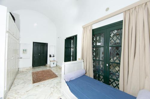 a bedroom with a bed and a green door at Arabesque House in La Marsa
