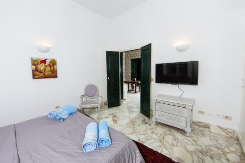 a bedroom with a bed and a flat screen tv at Arabesque House in La Marsa