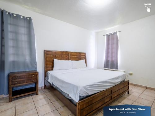 a bedroom with a wooden bed and a window at West Coast Inn's in Boqueron