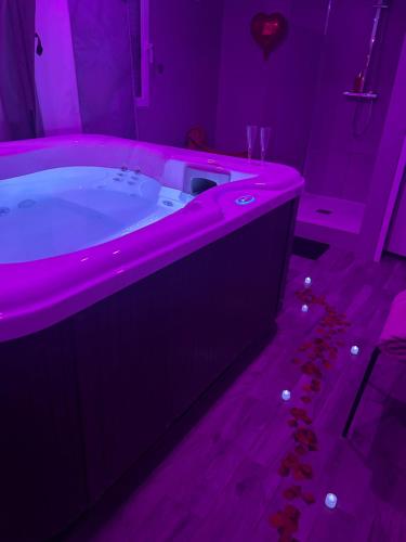 a purple bathroom with a tub with a pink lighting at Jacuzzi privé arrivée autonome in Conflans-Sainte-Honorine