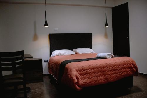 1 dormitorio con cama, escritorio y silla en PRANA HOTEL LOUNGUE BAR, en Huancayo