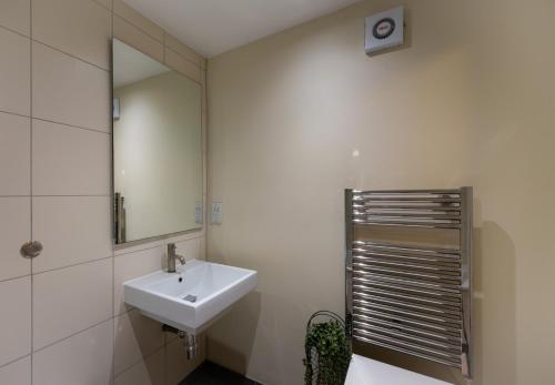 a white bathroom with a sink and a mirror at Modern Apartment in Central London By River Thames in London