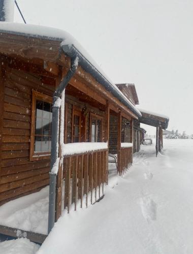a log cabin with snow on the roof at Dorotea Vista in Puerto Natales