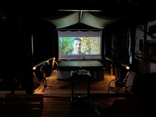 a stage with a screen with a man on it at Wayne's Place-Hot tub, pet friendly. Close to HPU in High Point