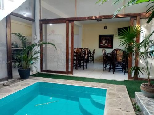 una piscina en medio de un patio con mesas y sillas en Hospedaje La Estancia Punta Sal, en La Bocana