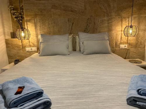 ミハスにあるCasa España en Mijas Pueblo 1habt. House 1 bedroomのベッド(白いシーツ、枕、タオル付)