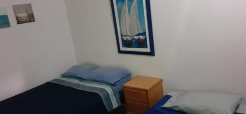 La Bocana的住宿－Hospedaje La Estancia Punta Sal，一间卧室设有两张床,墙上挂着一幅画