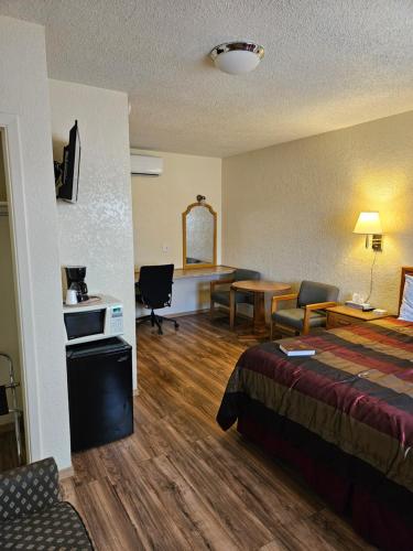 a hotel room with a bed and a desk at Travel Inn in Canon City