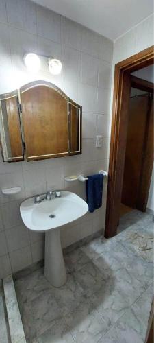 La salle de bains est pourvue d'un lavabo blanc et d'une douche. dans l'établissement Departamento en patio interno, à Necochea